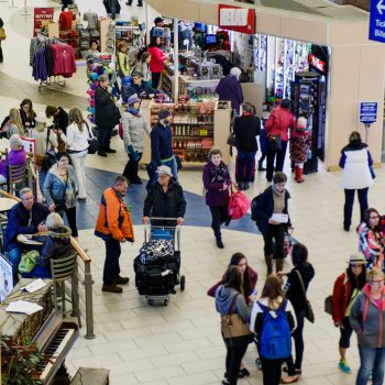 People walking with their luggages inside the airport