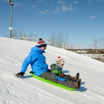 A family tobogganing down the snow
