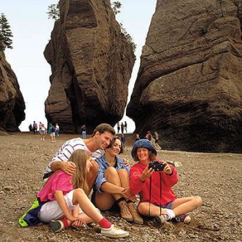 tourist taking a family photo by hopewell rocks